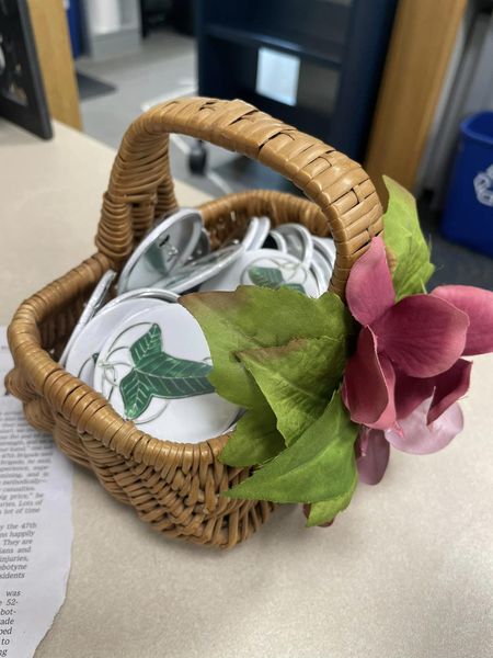Basket with pin buttons inside and a flower on the handle